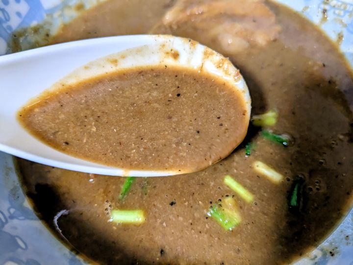 中華蕎麦 とみ田 つけめんのスープをレンゲですくっている様子